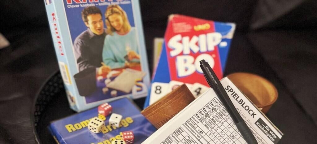 Valikoima lautapelejä, joihin kuuluvat muun muassa pelit nimeltä ”Clever Knobeln”, ”Skip-Bo” ja ”Rondo a Ringo”, sekä pelilauta ja noppia.