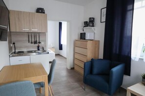 A compact living space with a kitchenette, a dining area, and a seating area.