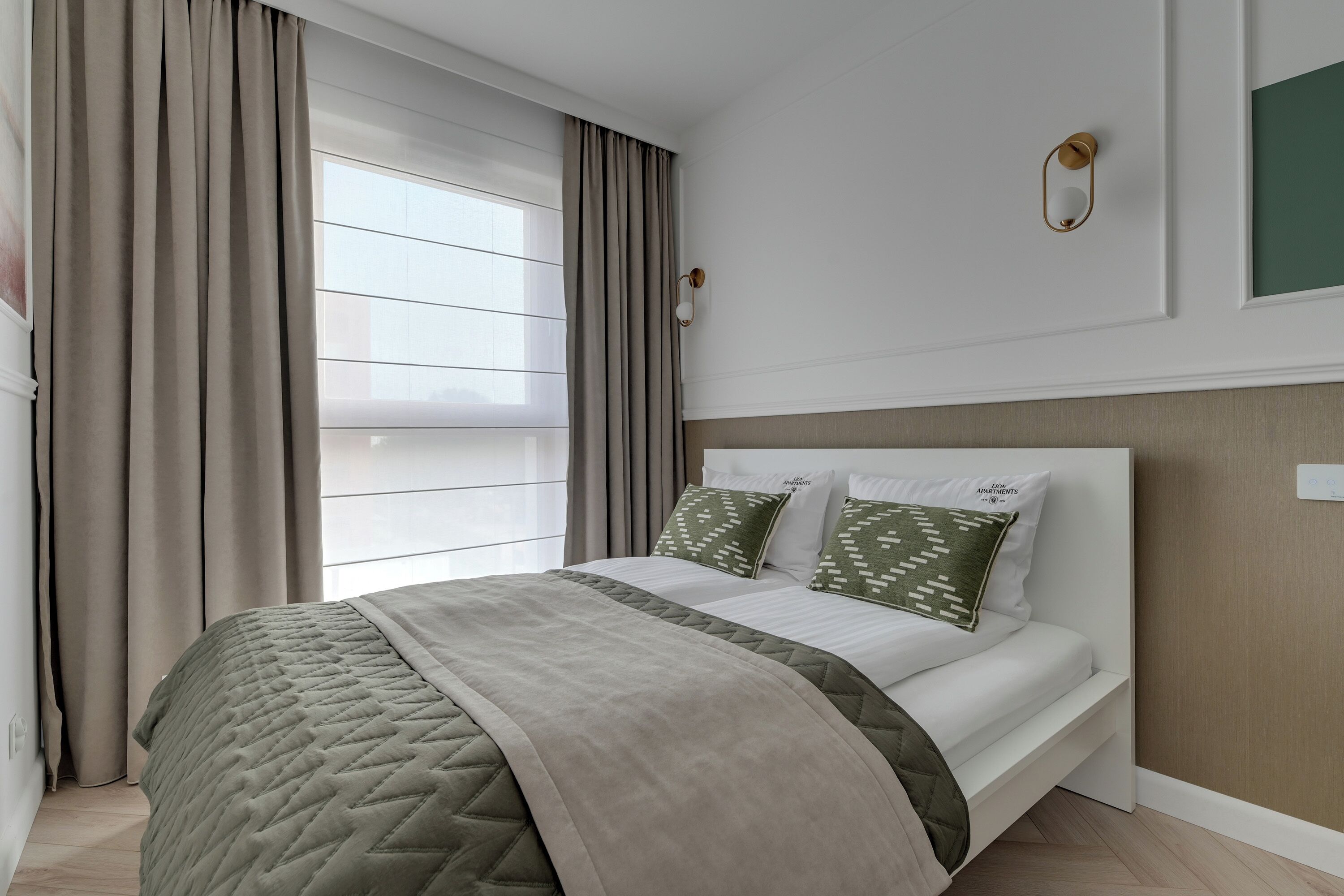 Un dormitorio moderno con cama, cortinas, una lámpara de pared y una ventana con persianas.