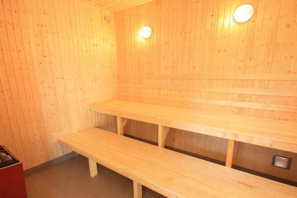 A sauna with wooden benches and a tiled floor.