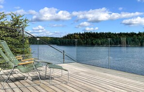 A wooden deck with outdoor seating and a view of a lake. - 2 bedroom beautiful home in Kinnarumma (Kinnarumma)