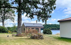A modern house with a metal roof, surrounded by trees and a lake. - 2 bedroom beautiful home in Kinnarumma (Kinnarumma)