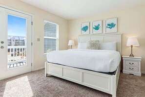 A bedroom with a bed, a nightstand, a lamp, and a window with blinds. - KULULA- Sleeps 19, 6 BR 5 BA, private pool, bikes & beach (Santa Rosa Beach)