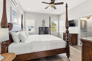 A bedroom with a four-poster bed, a ceiling fan, a television, and a bathroom with a vanity and sink. - KULULA- Sleeps 19, 6 BR 5 BA, private pool, bikes & beach (Santa Rosa Beach)