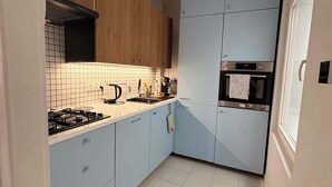 A compact kitchen with a gas stove, a coffee maker, and a built-in oven. - Spacious apartment in central Zielona Gora (Zielona Góra)