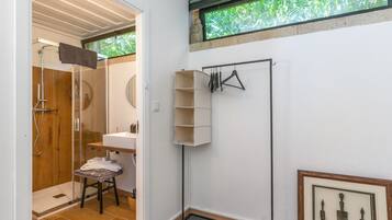 Un baño con ducha, lavamanos, toallero y un cuadro enmarcado en la pared.