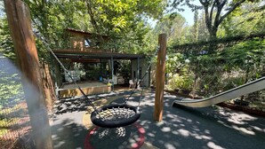 A playground with a swing set, a slide, and a covered play area with tables and chairs. - Suite Camélia Room with Shared Pool and Private Garden (Fornelos)