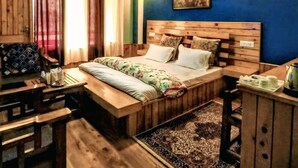 Un lit en bois avec une tête de lit, une table de chevet et une chaise.