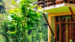Un bâtiment en bois doté d’un balcon donnant sur un paysage montagneux.