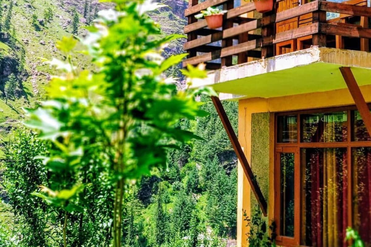 Un edificio de madera con balcón que da a un paisaje montañoso.