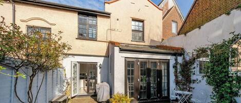 A residential property with a patio, a covered outdoor seating area, and a garden.