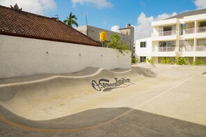 A concrete skate park with a curved ramp and the word 'Oxygen' painted on it. - O.Serendipity Kuta (Kuta)