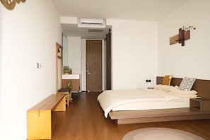 A modern bedroom with a bed, bedside table, and a small desk with a chair. - O.Serendipity Kuta (Kuta)