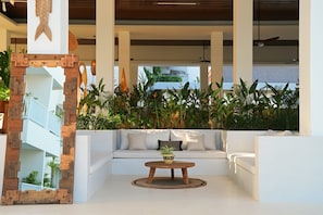 A modern interior with a white sofa, a wooden coffee table, and a decorative fish wall art piece. - O.Serendipity Kuta (Kuta)