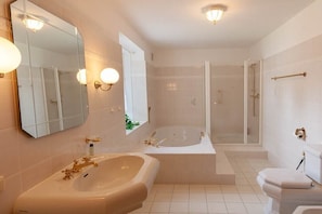 A bathroom with a large bathtub, a separate shower area, and a toilet. - Holiday apartment with 2 bedrooms (Braunlage)