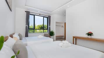 Una habitación de hotel moderna con dos camas, un ventanal grande y una mesita de noche de madera.
