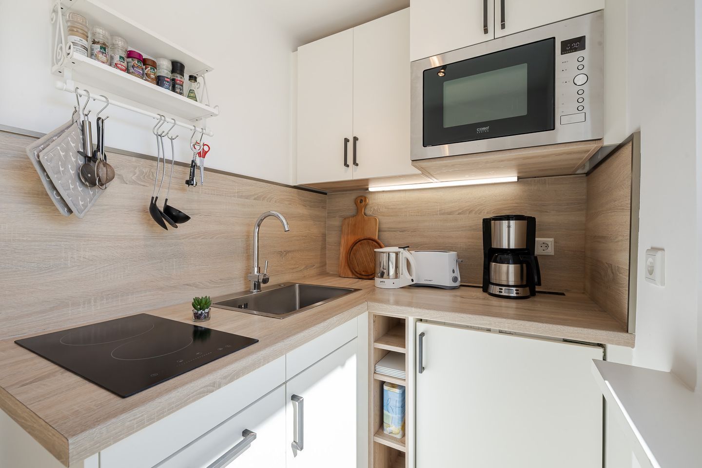 A modern kitchen with a built-in microwave, a coffee maker, and a toaster.