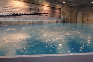 A hot tub with a stone wall backdrop and a tiled floor. - Holiday home in the North Sea with 3 bedrooms (Friedrichskoog-Spitze)