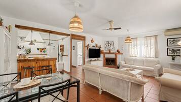 A spacious living area with a dining table, sofa, and a fireplace.