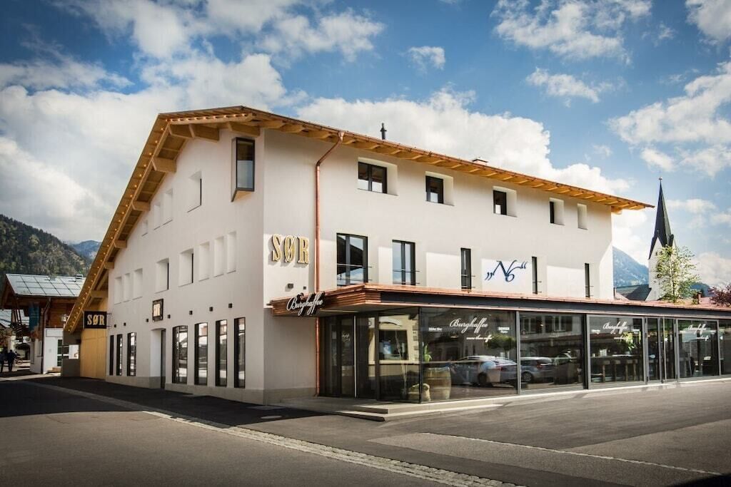 A building with a sign that reads 'SÖR' and a storefront with glass doors.