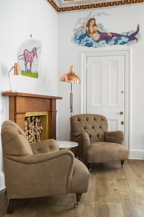 A room with two armchairs, a fireplace, and a wall mural. - Stay in one of Edinburgh’s most magical corners (Edinburgh)