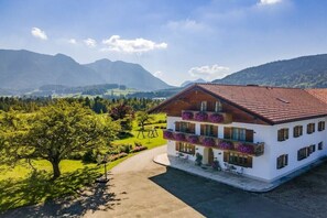 A two-story building with a balcony, surrounded by a well-maintained garden and a mountainous landscape. - Lavender - Sotterhof (Inzell)