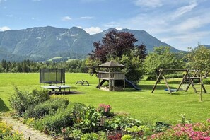A playground with a slide and swings, surrounded by a grassy field and a mountain backdrop. - Lavender - Sotterhof (Inzell)