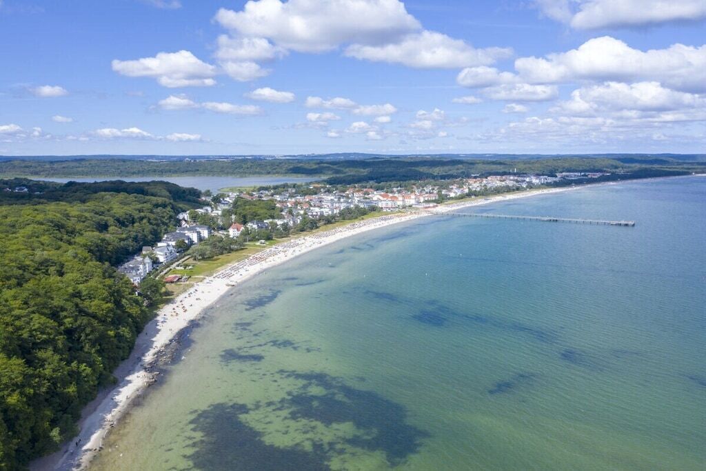 Une ville côtière dotée d’une plage, d’une jetée et d’une zone bois ée.