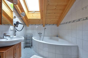 Un bagno con finestra sul tetto, una vasca e un lavandino.
