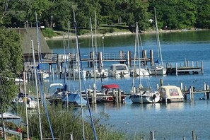 Ein Yachthafen mit verschiedenen Schiffen, umgeben von Grünpflanzen und ruhigem Wasser.