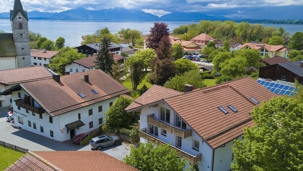 A residential area with houses, a church, and a lake in the background. - Holiday apartment with 1 bedroom (Seebruck)
