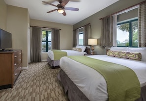 A hotel room with two beds, a ceiling fan, a TV, and a window with curtains. - Sevierville | Pool & Mountains | 2BR Condo (Sevierville)
