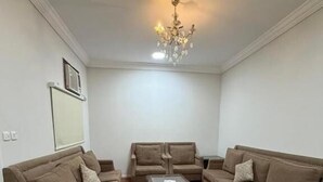 Una sala de estar con dos sofás, una mesa de centro y una araña.