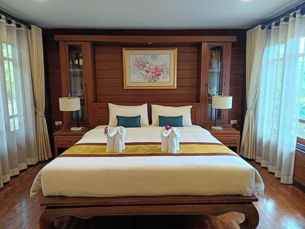 Una habitación de hotel con una cama grande, dos mesitas de noche, un cabecero de madera y un cuadro sobre la cama.
