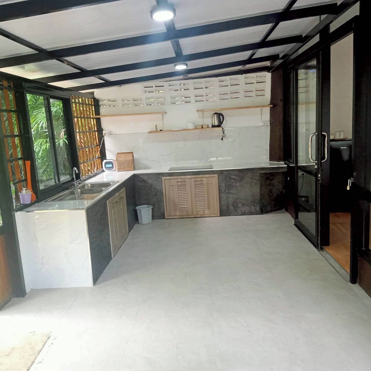 A kitchen with a built-in sink, a microwave, and a coffee machine.