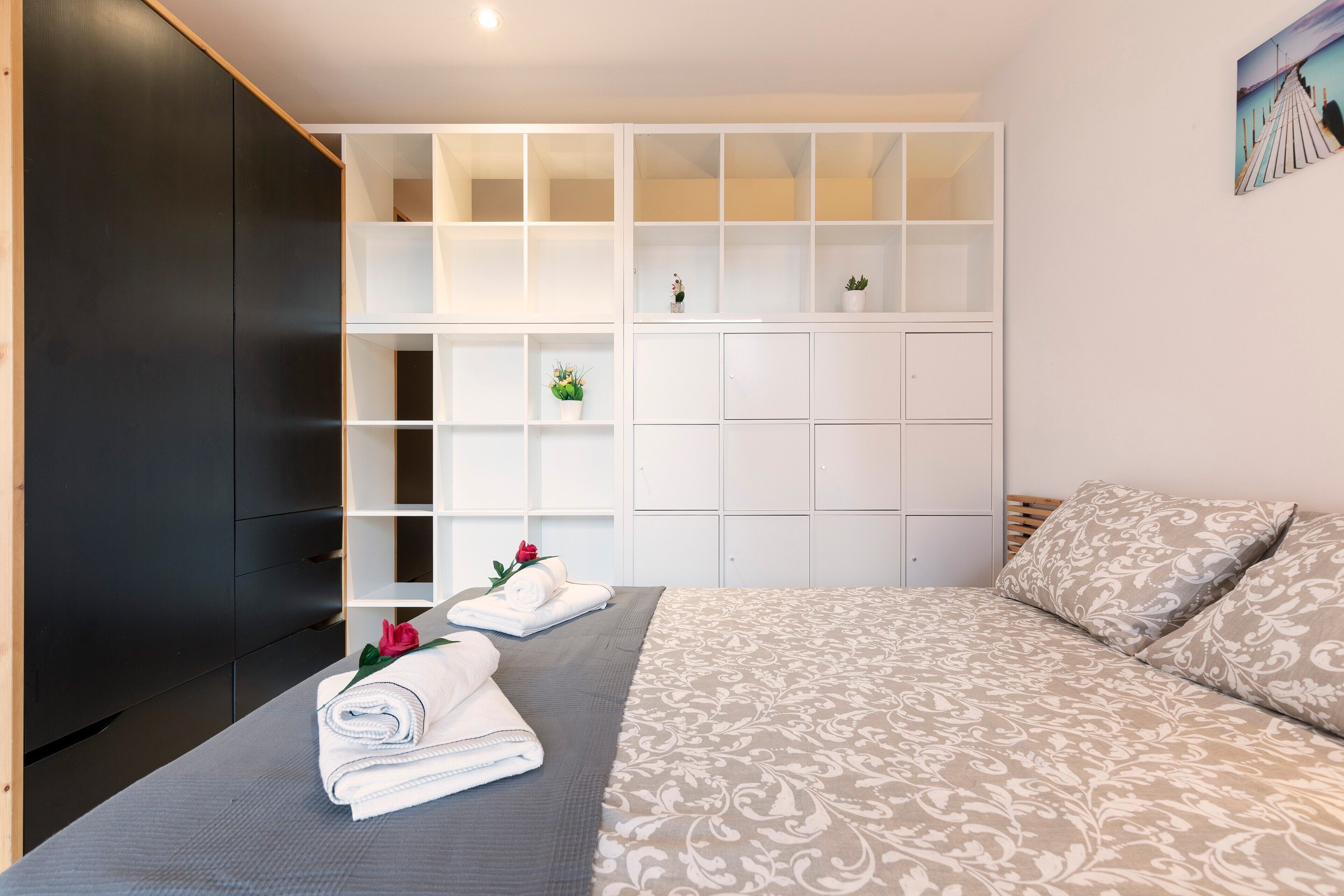 Een slaapkamer met een bed, een kledingkast en een inbouwkast.