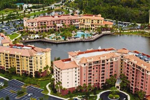 A large hotel complex with multiple buildings, a central courtyard, and a lake. - Orlando | Pool & Disney Access | 3BR Sleeps 10 (Lake Buena Vista)