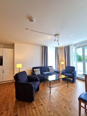 Ein stilvolles Wohnzimmer mit einer Couch, Sesseln und einem Couchtisch.
