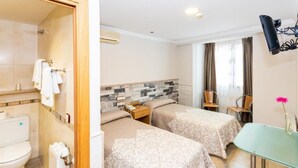 A hotel room with a shower, two beds, a small table, and a chair. - HOSTAL VIKY (Madrid)