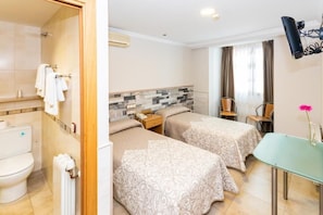 A hotel room with a shower, two beds, a small table, and a chair. - HOSTAL VIKY (Madrid)