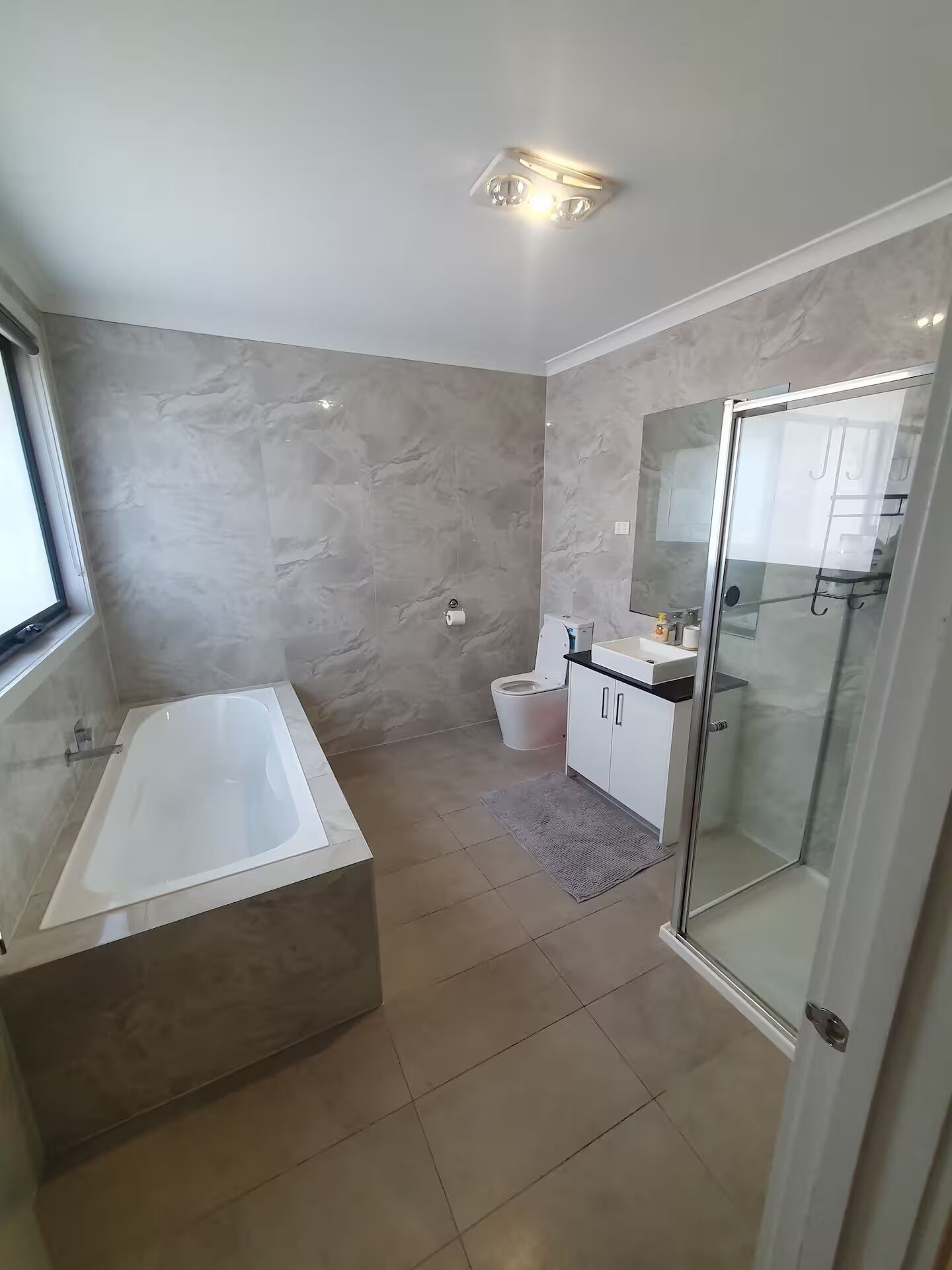Un baño moderno con bañera, inodoro y zona de ducha.