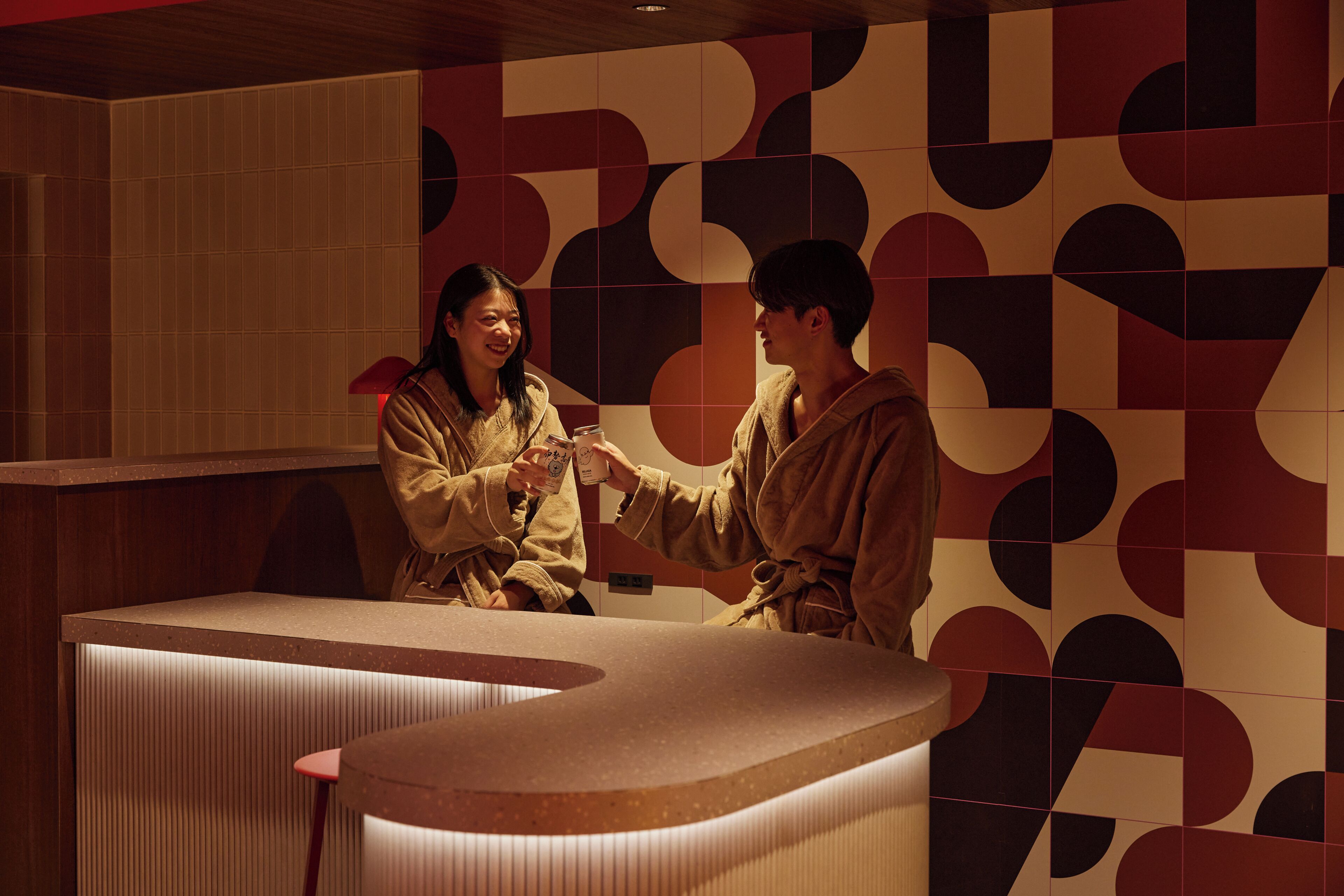Un espace d’accueil avec un comptoir et un mur décoré de motifs.