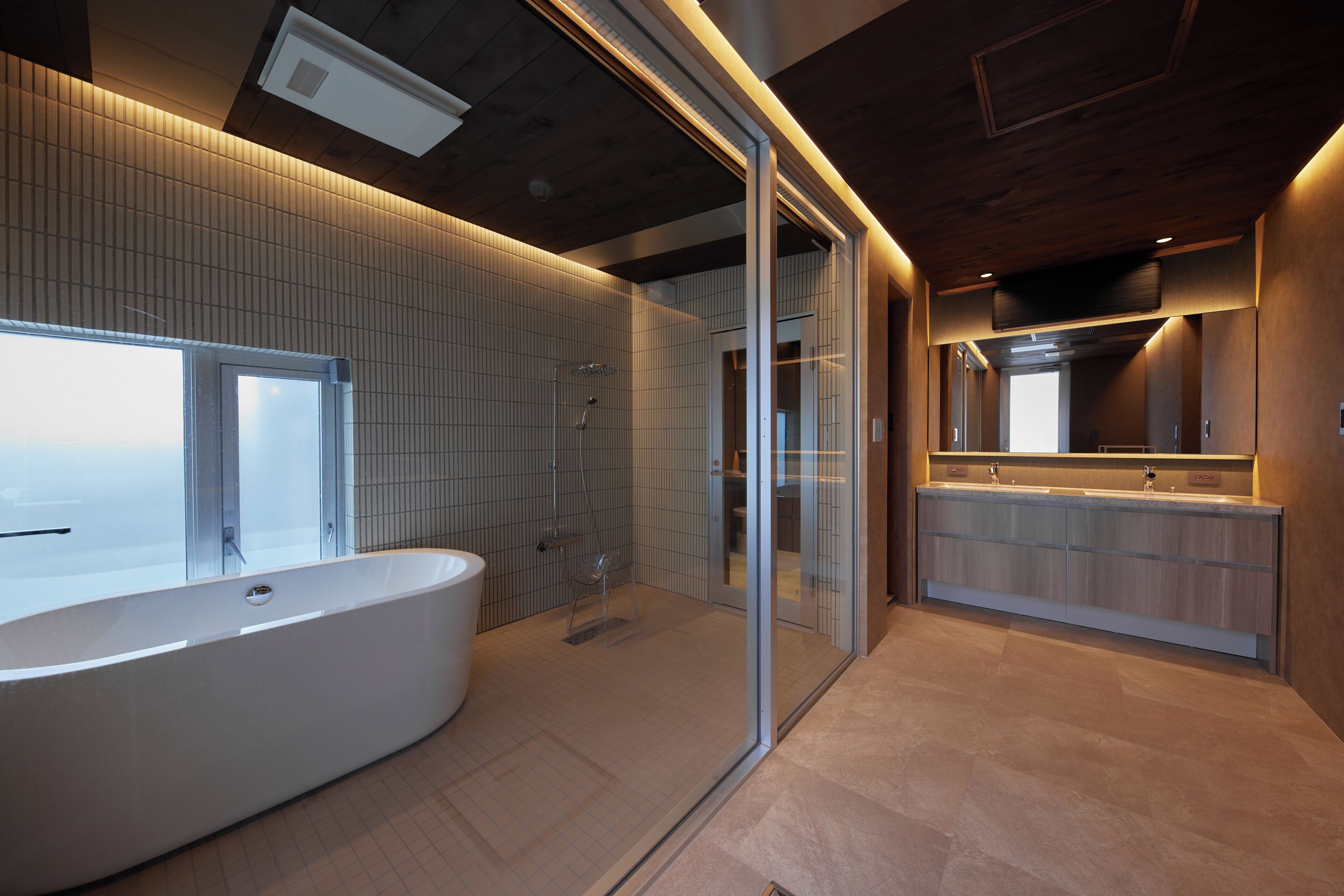 A modern bathroom with a freestanding bathtub, a glass-enclosed shower, and a vanity with a mirror.