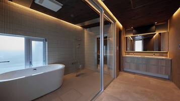 A modern bathroom with a freestanding bathtub, a glass-enclosed shower, and a vanity with a mirror.