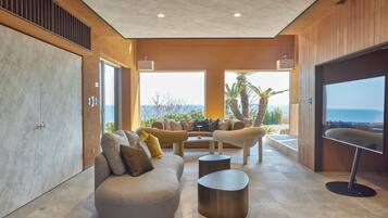 Un salon moderne avec un canapé, une table basse et une vue sur la mer.