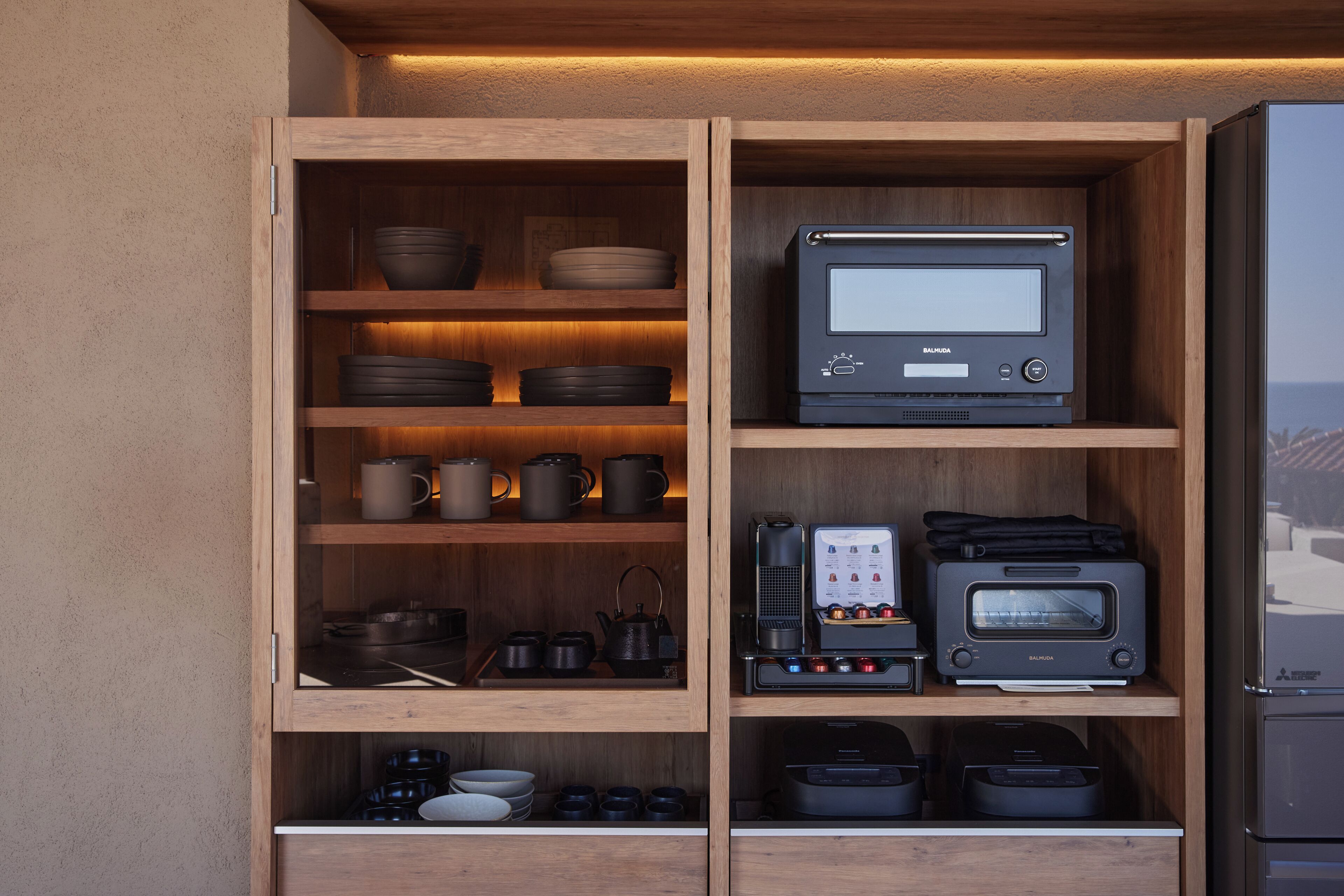 A kitchen with wooden cabinets, a built-in oven, a coffee maker, and various kitchenware.