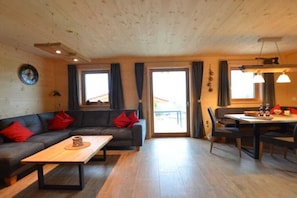 Ein gemütliches Wohnzimmer mit einer Couch, einem Couchtisch und einem Essbereich mit Stühlen und einem Tisch.