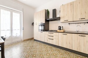 Eine moderne Küche mit Holzausstattung, einem Gasherd und einem Spülbecken.