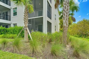 A modern building with multiple windows and balconies, surrounded by lush greenery and palm trees. - Punta Gorda Resort Condo: Pool Access, Lanai (Punta Gorda)