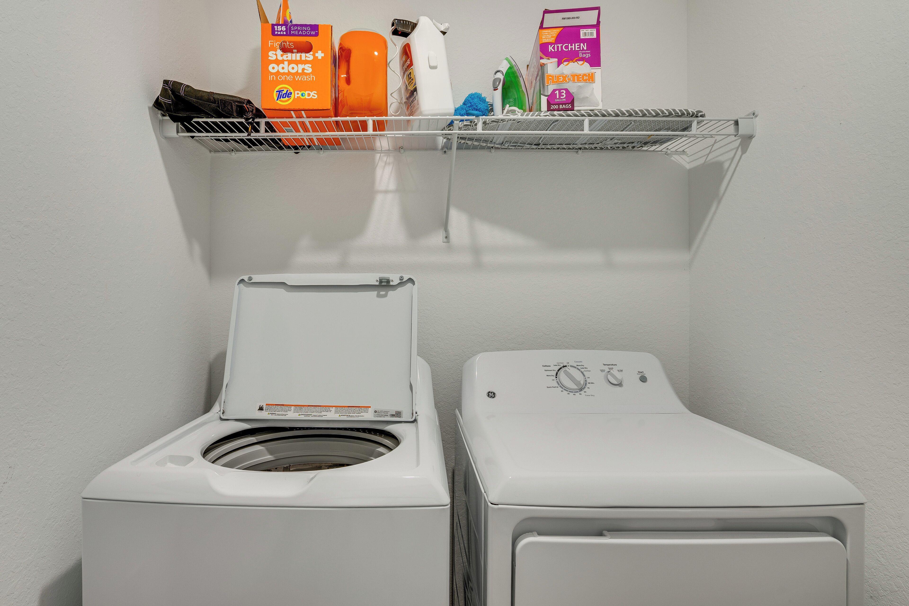 Un espace buanderie équipé d’un lave-linge à chargement frontal et d’un sèche-linge.